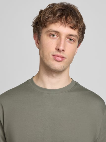 Männermodel trägt Relaxed Fit T-Shirt aus reiner Baumwolle Modell 'FRED LIFE' von Only & Sons, unifarben, Nahaufnahme Oberkörper.