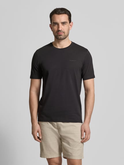 Männermodel trägt T-Shirt mit Label-Detail von bugatti in Schwarz, aus reiner Baumwolle, gerader Schnitt, Rundhalsausschnitt, Ganzkörperansicht von vorne.