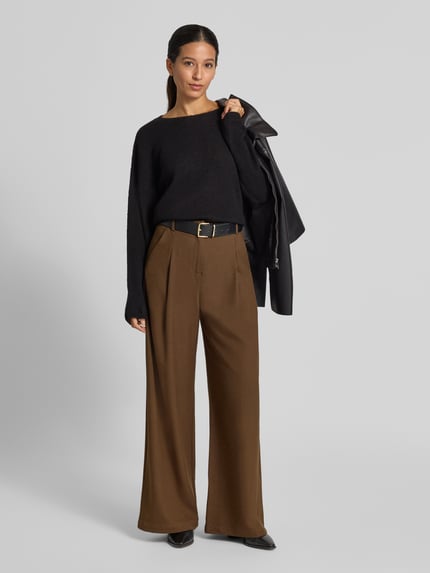 Frauenmodel trägt Strickpullover aus Woll-Mix mit Alpaka-Anteil Modell 'IMENY' von DRYKORN, Oversized Fit, U-Boot-Ausschnitt, schwarze Farbe, glatte Textur, Ganzkörperansicht von vorne.