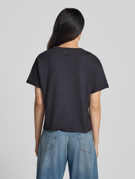 Vrouwenmodel draagt t-shirt met fixeerde mouwboorden Model 'ROSIE' van ba&sh, puur katoen, los model, ruglengte maat S: 56 cm, geheellichaamsaanzicht rugaanzicht.