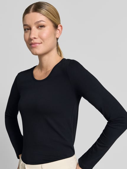 Frauenmodel trägt Longsleeve mit Rundhalsausschnitt von ZABAIONE im Baumwoll-Elasthan-Mix, Schwarz, taillierter Schnitt, Nahaufnahme Oberkörper.