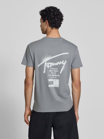 Männermodel trägt Regular Fit T-Shirt aus reiner Baumwolle von Tommy Jeans, Optik: Unifarben, Label-Schriftzug, Ganzkörperansicht Rückansicht.