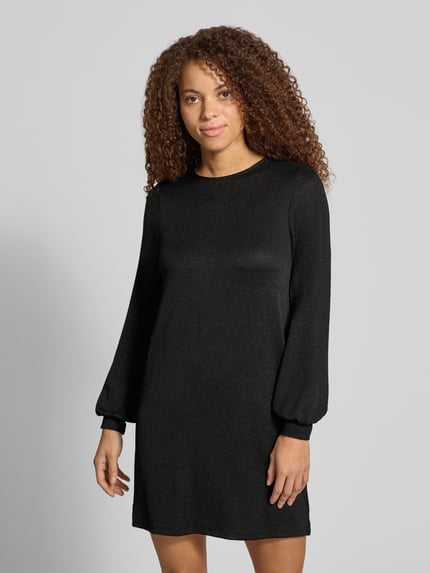 Frauenmodel trägt Langarmshirt mit Glitzerstruktur von ONLY in Schwarz, unifarben, strukturierte Jersey-Oberfläche, Ganzkörperansicht von vorne.