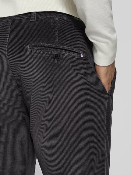 Männermodel trägt Modern Fit Cordhose aus Baumwoll-Mix Modell 'Fabio' von Brax in anthrazit mit feiner Rippenstruktur, Nahaufnahme Rückansicht, Herren Schmale Hose von Brax