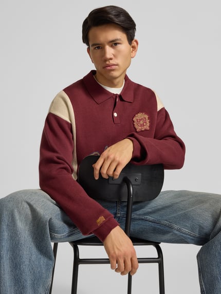Männermodel trägt Strickpullover mit Polokragen und Label-Patch von PROHIBITED in Bordeaux, Relaxed-Fit, Reine Baumwolle, Nahaufnahme Oberkörper.