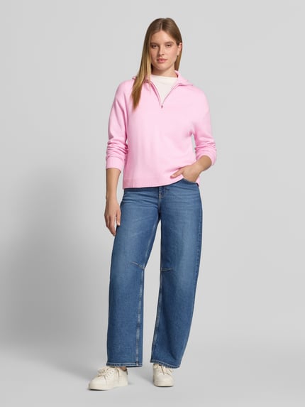 Frauenmodel trägt Troyer mit halblangem Reißverschluss Modell 'RIZIN' von MANGO in Rosa, Strickoptik, Regular Fit, Ganzkörperansicht von vorne.