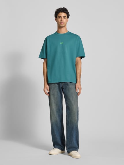 Männermodel trägt Oversized T-Shirt aus reiner Baumwolle Modell 'NALONO' von Hugo Blue, unifarben, Rundhals, kurzarm, Ganzkörperansicht von vorne.