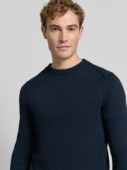 Männermodel trägt Pullover mit markanten Teilungsnähten von S.OLIVER CASUAL in Dunkelblau, Struktur-Strick, Nahaufnahme Oberkörper.