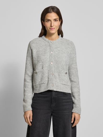 Frauenmodel trägt Strickjacke mit Knopfleiste von Rich & Royal, meliert grau, lockerer Schnitt, gerippte Abschlüsse, Ganzkörperansicht von vorne.