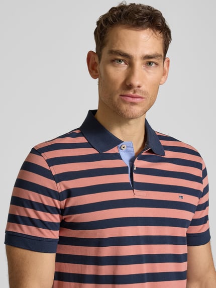 Männermodel trägt Modern Fit Poloshirt mit Logo-Stitching von Christian Berg Men aus Reine Baumwolle, Polokragen, kurze Knopfleiste, Nahaufnahme Oberkörper.