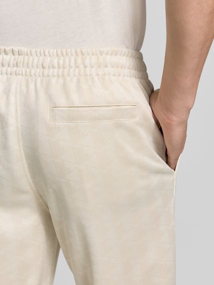 Männermodel trägt Regular Fit Sweathose aus Baumwoll-Mix von Lacoste, cremefarben mit feinem Muster, Nahaufnahme Hüfte, Herren Sweathose von Lacoste.