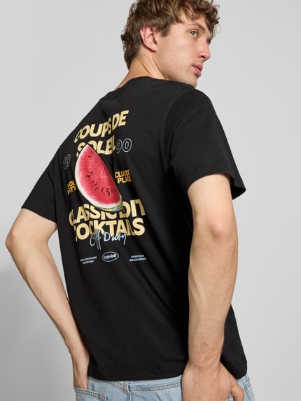 Männermodel trägt T-Shirt mit Logo-Print Modell 'RIVIERA VINTAGE POSTER' von JACK & JONES, schwarze Baumwolle, Motiv-Print hinten, Ganzkörperansicht Rückansicht.