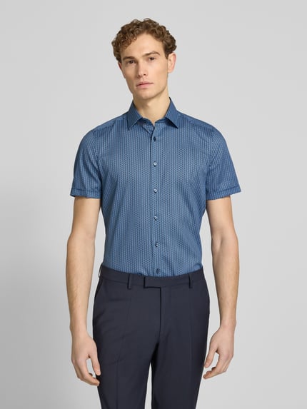 Männermodel trägt Slim Fit Business-Hemd im Allover-Look mit Kentkragen von OLYMP Level Five, Baumwoll-Elasthan-Mix, Ganzkörperansicht von vorne.