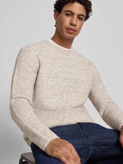 Männermodel trägt Regular Fit Strickpullover mit Woll-Anteil Modell 'BAY' von Only & Sons in Melange-Optik, Rundhals, Langarm, Strickstruktur, Nahaufnahme Oberkörper.