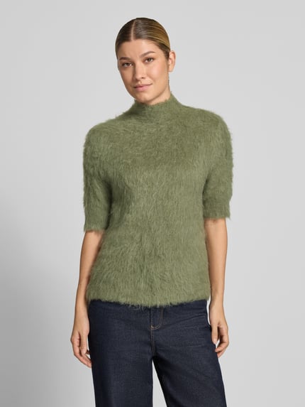 Frauenmodel trägt Strickshirt aus Alpaka-Mix mit kurzem Stehkragen von someday, körpernaher Schnitt, olivgrün, Ganzkörperansicht von vorne.