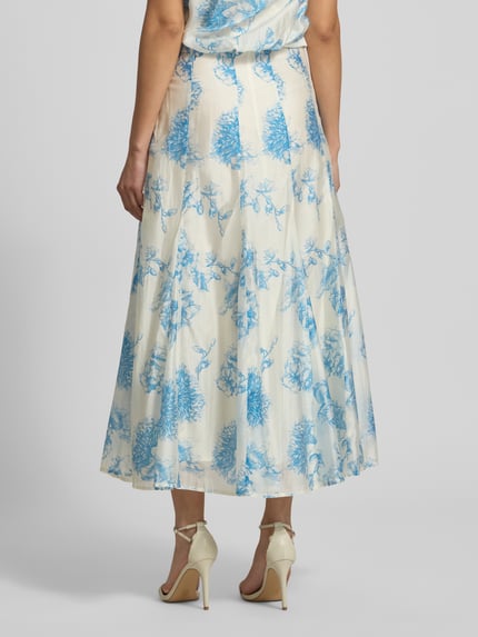 Frauenmodel trägt Maxirock aus Lyocell-Mix Modell 'Evangelia' von MSCH Copenhagen mit blauem floralem Allover-Print, Ganzkörperansicht Rückansicht.