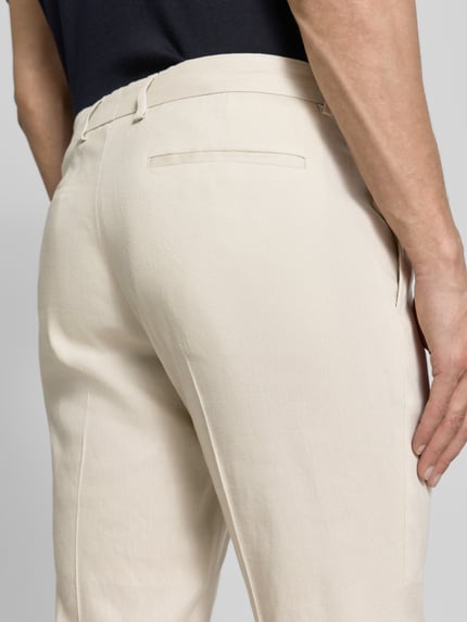 Männermodel trägt Regular Fit Anzughose aus Leinen-Mix van s.Oliver BLACK LABEL, look: effen, pasvorm: regular fit, steekzakken, achterzak, materiaal: linnenmix. Detailaufnahme achterkant.