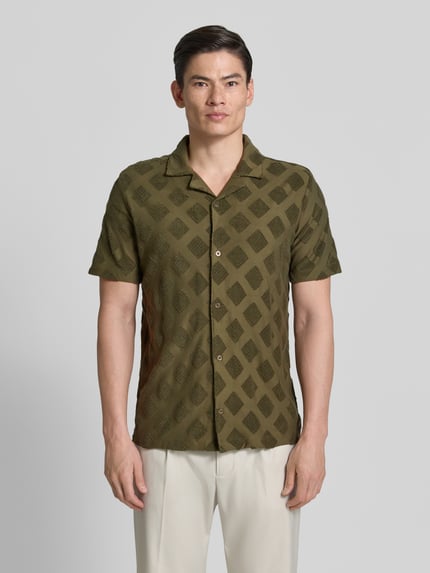 Mannenmodel draagt Slim Fit Poloshirt met structuurpatroon van Fynch-Hatton in katoenmix, reverskraag, korte mouw, knoopsluiting, ruglengte maat M 74 cm, heren poloshirt. Ganzkörperansicht van voren.