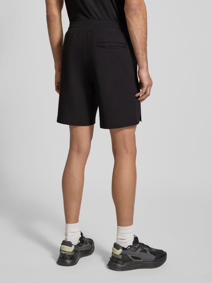 Mannelijk model draagt zwarte Shorts mit Logo Modell 'CLOUDSPUN 7' van PUMA PERFORMANCE, regular fit, elastische band, productfoto, volledig lichaamsbeeld achteraan.