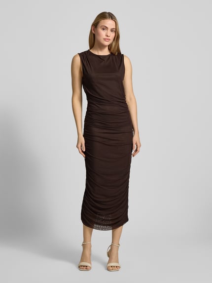 Frauenmodel trägt figurbetontes Maxikleid mit Rundhalsausschnitt Modell 'Corilina Solid' von Neo Noir in Braun, Material-Mix mit Stretch, seitliche Raffungen, Ganzkörperansicht von vorne.