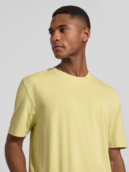 Männermodel trägt Regular Fit T-Shirt aus Baumwoll-Mix Modell 'TCHUP' von BOSS Orange, unifarben, Rundhals, Kurzarmlänge, Nahaufnahme Oberkörper.