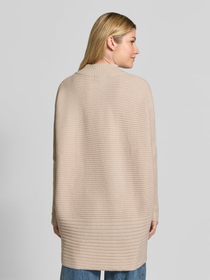 Frauenmodel trägt Strickpullover mit Stehkragen von Apricot, beiger Material-Mix, Relaxed Fit, Teilungsnähte, Ganzkörperansicht Rückansicht.