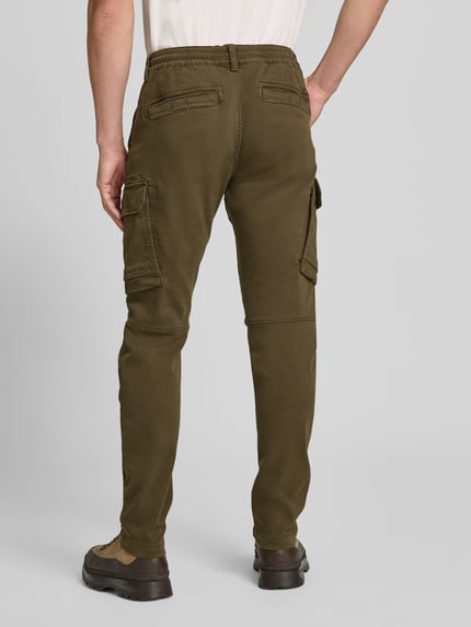 Männermodel trägt olivgrüne Cargohose mit Pattentaschen Modell 'EXPEDIZOR' von PME Legend, Skinny Fit, Ganzkörperansicht Rückansicht.