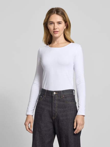 Frauenmodel trägt Longsleeve mit geripptem Rundhalsausschnitt von ZABAIONE, weiß, enger Schnitt, glatte Textur, Nahaufnahme Oberkörper.
