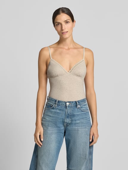 Frauenmodel trägt Slim Fit Body aus Modal-Mix von Jake*s Casual in Beige mit feiner Spitze, blaue Jeans, Ganzkörperansicht von vorne.