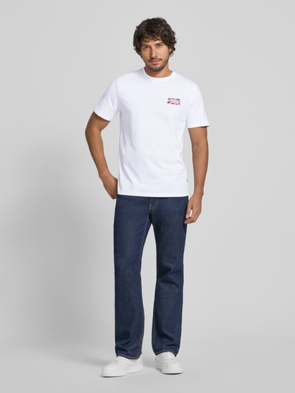 Männermodel trägt Regular Fit T-Shirt aus reiner Baumwolle Modell 'SMALL FLAG' von Pepe Jeans in Optik: Unifarben mit Motiv-Print, Jersey, Rundhals, Kurzarm, Ganzkörperansicht von vorne.