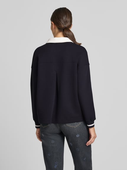 Frauenmodel trägt Relaxed Fit Sweatshirt aus Baumwoll-Mix von Marc Cain, Polokragen, Knopfleiste, Motiv-Print, Ganzkörperansicht Rückansicht.