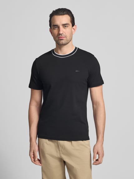 Männermodel trägt Regular Fit T-Shirt aus Baumwoll-Mix von Lacoste, Optik: Unifarben, Logo-Stitching, Piqué, Ganzkörperansicht von vorne.