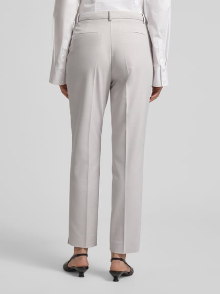 Vrouwenmodel draagt Hose mit Bügelfalten und Eingrifftaschen van More & More, materiaalmix met viscose, slim fit, persplooien, steekzakken, achterzakken, bandwijdte maat 36: 39 cm, binnenbeenlengte maat 36: 75 cm, Ganzkörperansicht Rückansicht.