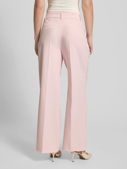 Vrouwenmodel draagt Wide Fit stoffen broek met persplooien van Christian Berg Woman Selection, elastische materiaalmix, achterzakken, haakjes- en ritssluiting, kleur lichtroze, Ganzkörperansicht Rückansicht.