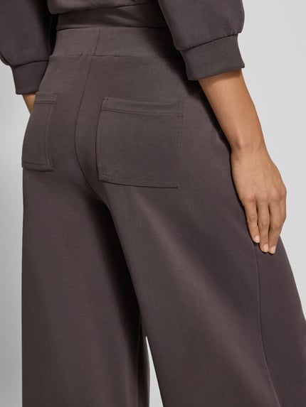 Frauenmodel trägt Culotte mit Gesäßtaschen Modell 'Peach' von Rich & Royal, braun, weiche Micromodal-Textur, Detailaufnahme Rückansicht.