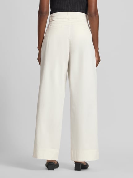 Frauenmodel trägt Wide Leg Chino aus Baumwoll-Mix Modell 'C_Tanjura5-D' von BOSS für BOSS Orange, cremefarben, Ganzkörperansicht Rückansicht.