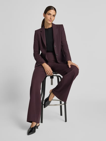 Frauenmodel trägt Slim Fit Blazer mit Viskose-Anteil von windsor., elastyczna mieszanka materiałów z dodatkiem wiskozy, krój slim fit, kołnierz z połami, listwa guzikowa, kieszenie z patką, długość tyłu w rozmiarze 36: 67 cm, szerokość w rozmiarze 36: 39 cm, długość rękawów w rozmiarze 36: 62 cm, ciemnofioletowy, proste nogawki, klasyczna struktura, Ganzkörperansicht von vorne.
