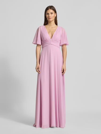 Kobiece modelka nosi Sukienka wieczorowa Regular Fit Abendkleid mit V-Ausschnitt von Jake*s Cocktail z szyfonu, dekolt w serek, krój regular fit, plisy, rękaw o dł. 1/2, dekolt na plecach, wszyty zamek błyskawiczny, halka pod spódnicę, długość tyłu w rozmiarze 36: 126 cm, szerokość w rozmiarze 36: 40 cm, długość rękawów w rozmiarze 36: 29 cm, pastelowy róż, gładka faktura, cała sylwetka z przodu