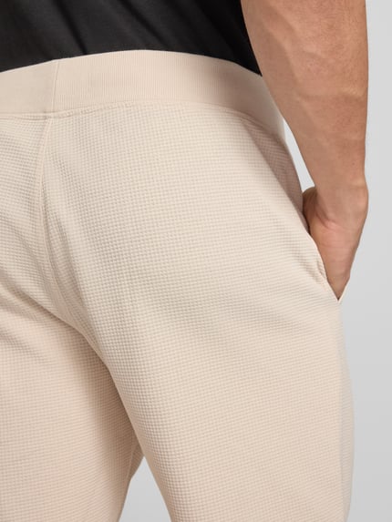 Männermodel trägt Straight Fit Shorts mit Strukturmuster von G-Star Raw im Elastischer-Material-Mix mit Logo-Detail, Detailaufnahme Rückansicht.