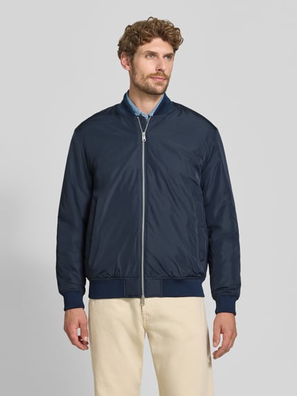 Männermodel trägt Regular Fit Bomberjacke mit Baseball-Kragen Modell 'CHARLES' von Selected, dunkelblau, glatte Textur, Ganzkörperansicht von vorne.