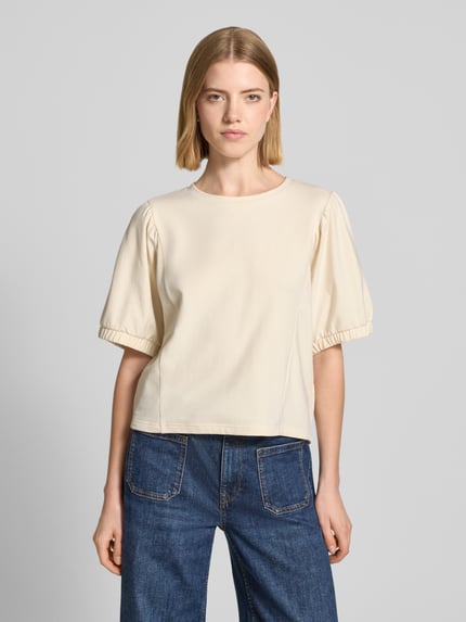 Modelka kobieca nosi Relaxed Fit Sweatshirt mit Rundhalsausschnitt Modell 'Aurati' od Drykorn, kremowy, gładka faktura, półrękaw, elastyczne zakończenia rękawów, bawełniany materiał, widok całej sylwetki z przodu.