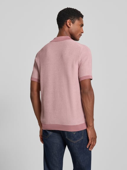 Męski model nosi koszulkę polo Slim Fit Poloshirt mit Strukturmuster model 'Brianoro' von JOOP! COLLECTION z bawełny, strukturalny wzór, listwa guzikowa, detal z logo, długość tyłu w rozmiarze M: 70 cm, jasnoróżowa, proste rękawy, fakturowana powierzchnia, Ganzkörperansicht Rückansicht.