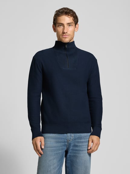Männermodel trägt Troyer aus reiner Baumwolle mit Reißverschluss-Detail von TOM TAILOR DENIM in Unifarben und Strickoptik, Ganzkörperansicht von vorne.