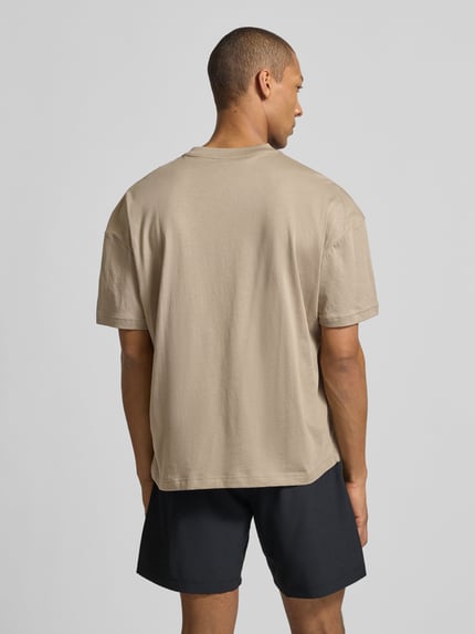 Männermodel trägt T-Shirt mit Logo und Rundhalsausschnitt von EA7 Emporio Armani, Regular-Fit aus reiner Baumwolle, Rückansicht Ganzkörperansicht.