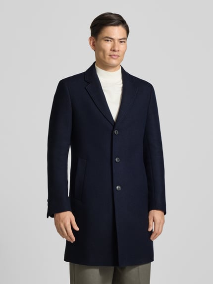 Männermodel trägt Slim Fit Mantel mit einreihiger Knopfleiste von BOSS, unifarben dunkelblau, Wollmix, Longline, Ganzkörperansicht von vorne.