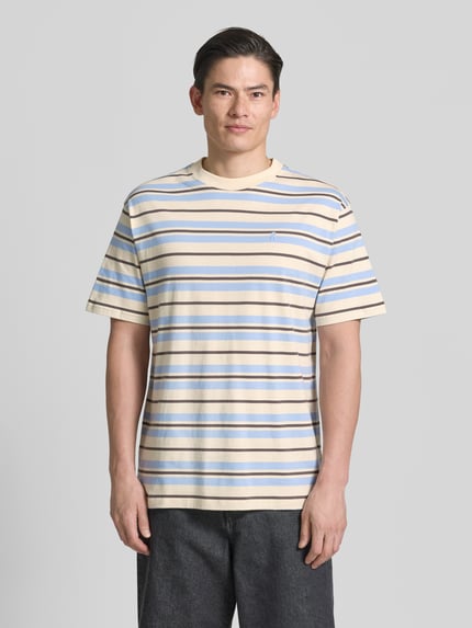 Männermodel draagt Relaxed Fit T-shirt aus reiner Baumwolle Modell 'MAARKOS' van Armedangels, meerkleurig gestreept, labelpatch, logostitching, ronde hals, korte mouw, jersey, puur katoen, Ganzkörperansicht van voren.