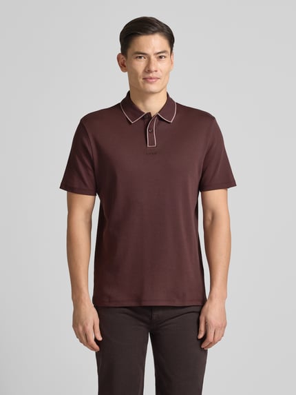 Männermodel trägt Regular Fit Poloshirt aus reiner Baumwolle Modell 'DALUMO' von HUGO, Optik: Unifarben, Ganzkörperansicht von vorne.