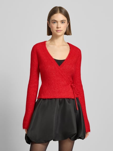Vrouwenmodel draagt Cardigan in wikkellook van Gina Tricot, materiaalmix met alpacawol, slim fit, V-hals, ruglengte 47 cm, mouwlengte 66 cm, Ganzkörperansicht von vorne.