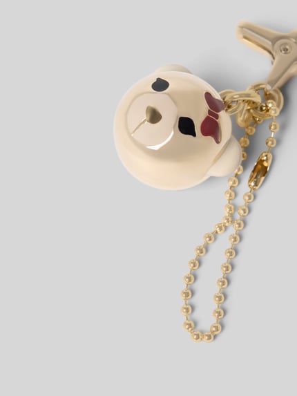 Produktfoto, zawieszka z metalu Model 'HASHTAG LADY BEAR SPHERE' od FURLA, kremowa głowa misia z czarnymi i bordowymi detalami, Łańcuszek, Metal, kontekst: zawieszka damska