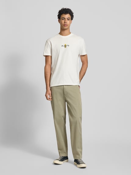 Männermodel trägt Tapered Chino aus Baumwoll-Mix Modell 'SONNY' von Tommy Jeans, Optik: Unifarben, Regular-Fit, Ganzkörperansicht von vorne.